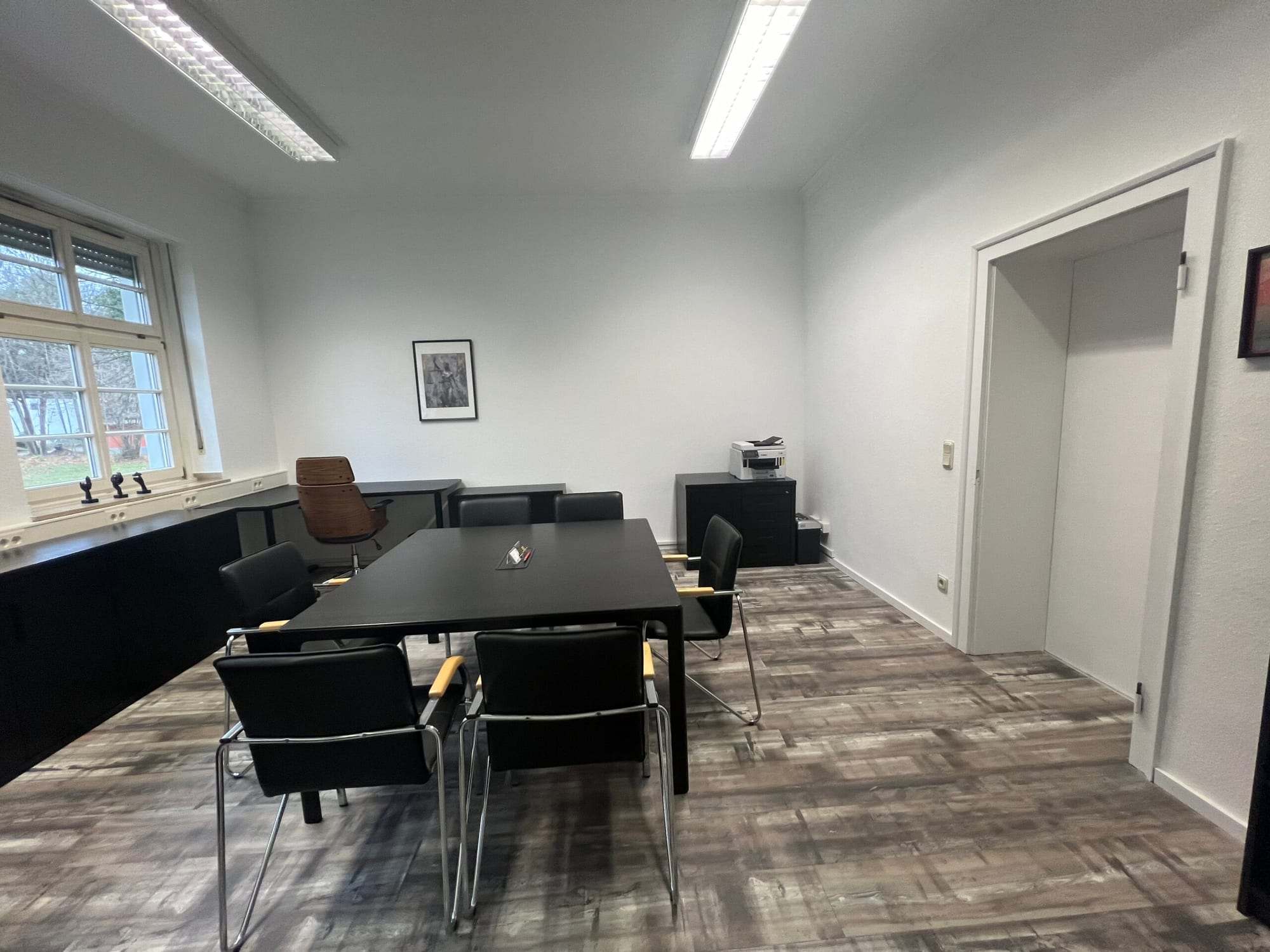 Toplantı masası ve yan odaya açılan kapısı olan oda