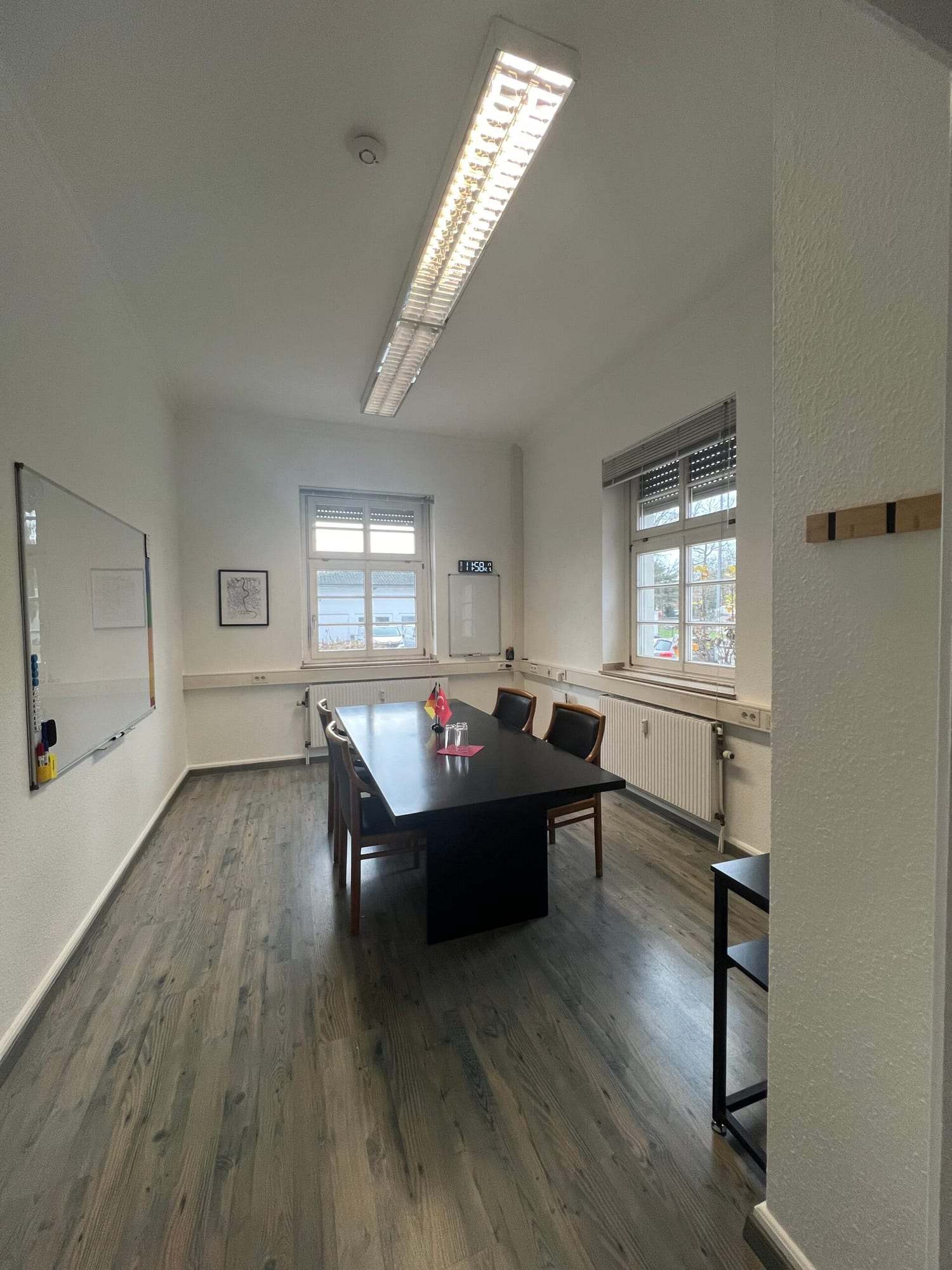 Pencereleri ve beyaz tahtası olan uzun konferans odası