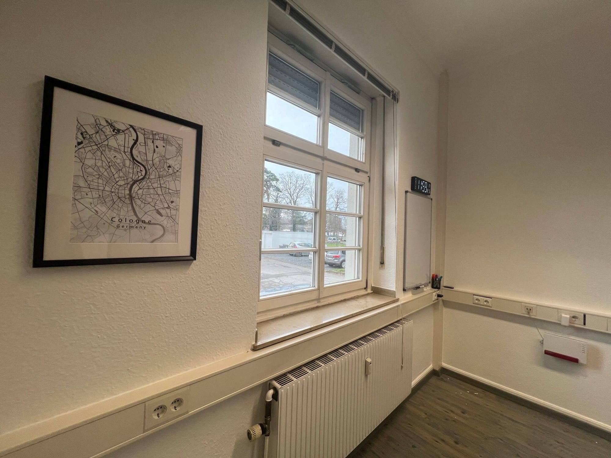 Duvarda çerçeveli şehir haritası ve pencere bulunan oda