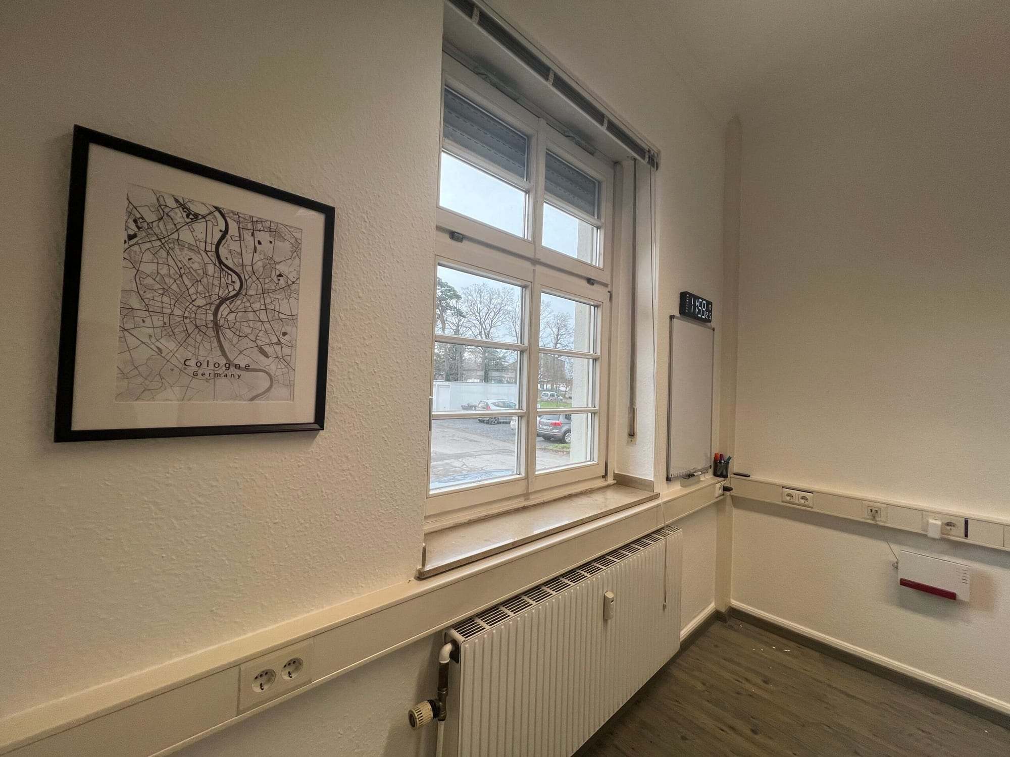 Duvarda çerçeveli şehir haritası ve pencere bulunan oda