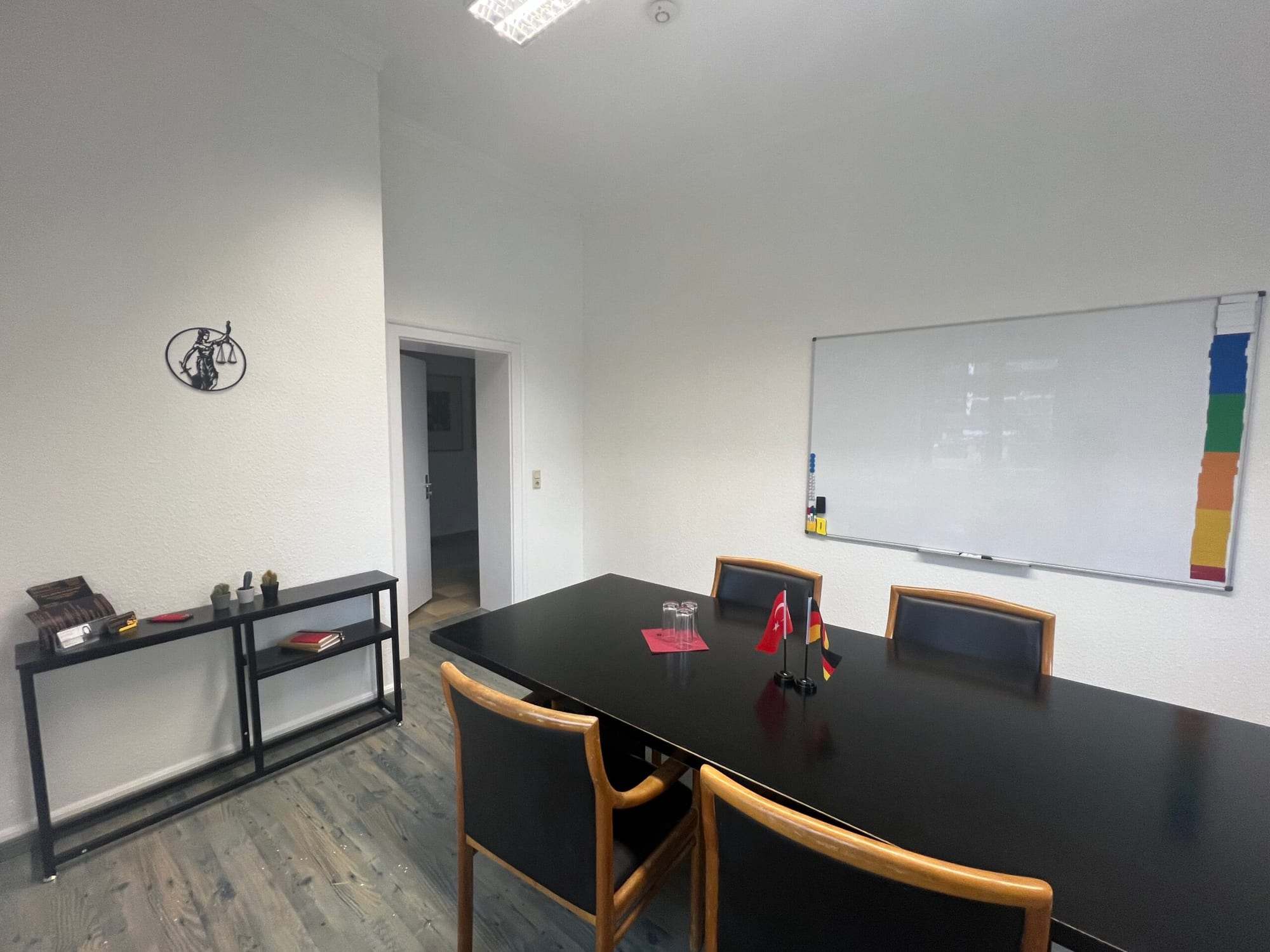 Beyaz tahtanın önünde sandalyeli toplantı masası